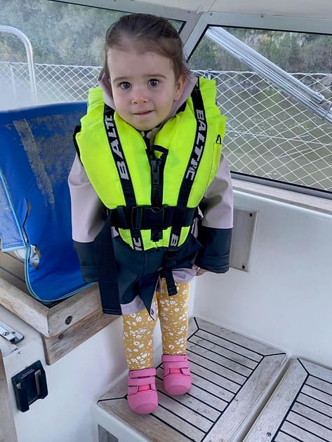 Toddler wearing a Bambi Baltic lifejacket Toddler wearing a Bambi Baltic lifejacket on a sailboat
