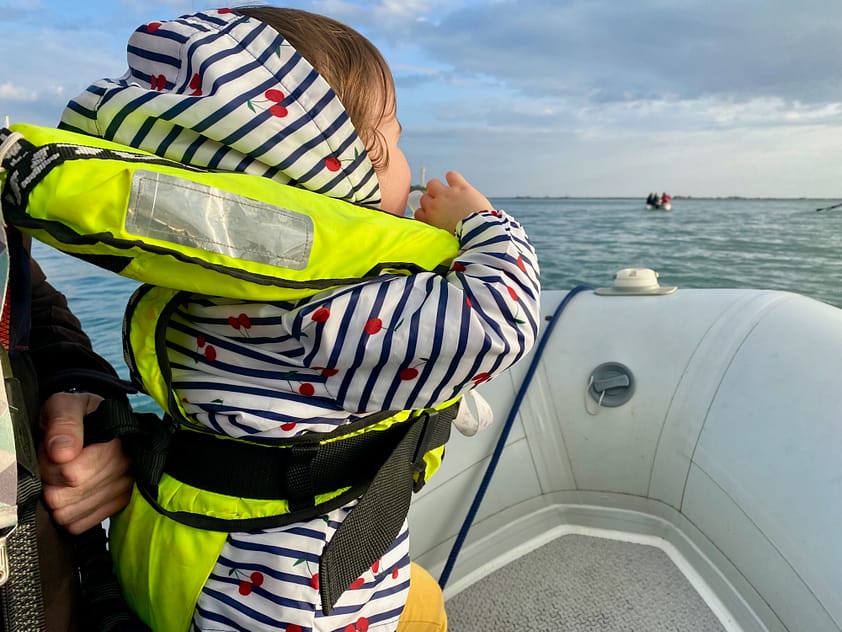 Toddler wearing a Bambi Baltic lifejacket on a sailboat Toddler wearing a Bambi Baltic lifejacket on a sailboat
